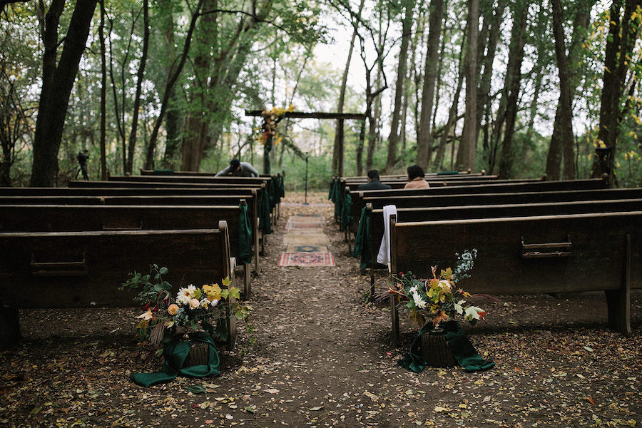 Eine idyllische Hochzeit mitten im Wald geschmückt mit Blumengestecken