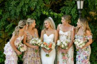 Brautjungfern in floralen Kleidern sehen sommerlich aus