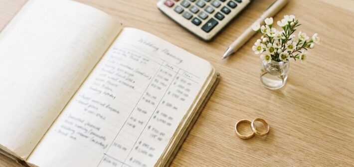Notizbuch mit Budgetplanung und Blumen auf einem Tisch